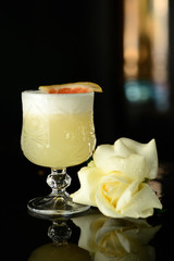 white cocktail with citrus and ice on a black background