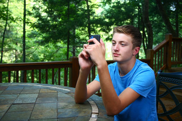 Young Man Using Cellphone On Deck At Cabin