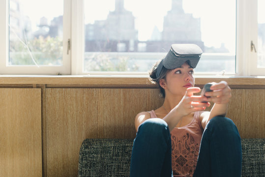 Young woman playing with virtual reality headset at home