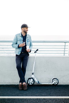 Man with scooter on bridge