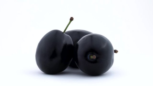 Three whole plum fruits. Rotated on the turntable. Isolated on the white background. Close up.