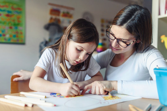 Mother with her child having creative and fun time drawing