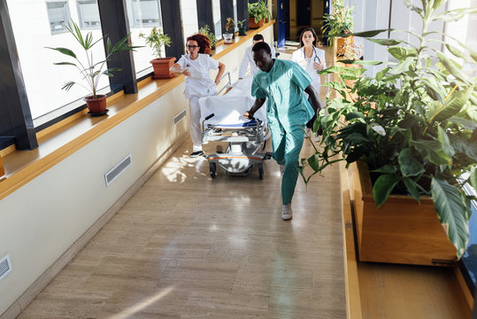 Medics running with bed in hospital