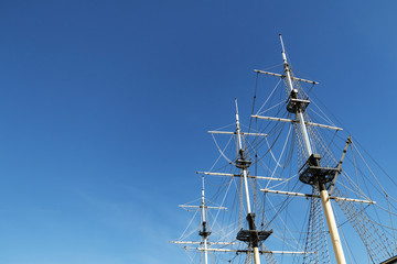 Sea ship masts and ropes against blue sky. Concept of travel, adventure and sea. Copy space.