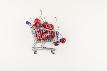 Ripe cherries in a shopping cart isolated
