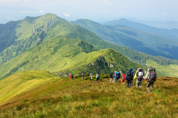 Group of tourists with large backpacks are on mountain