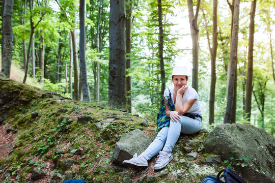 Woman sitting on a stone in forest during adventures