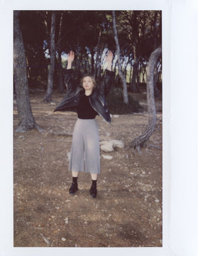 Full length of girl with raised arms in forest.