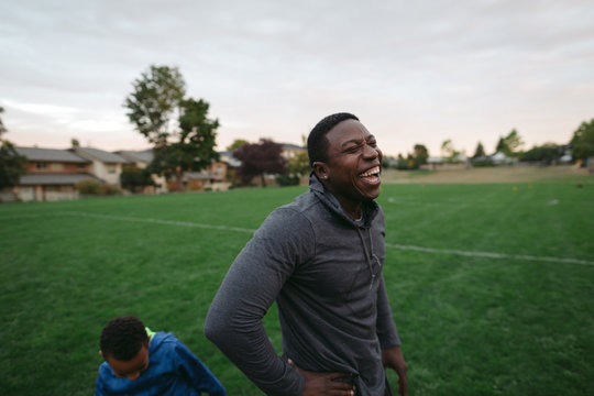 Man and boy enjoying each other and laughing in field