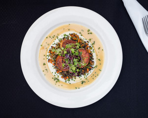 3 seared scallops served with cream sauce, roasted carrots, beets, and topped with field micro greens