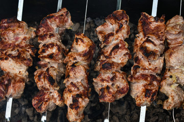 The barbecue is cooked on the coals. Pieces of meat on skewers in barbecue