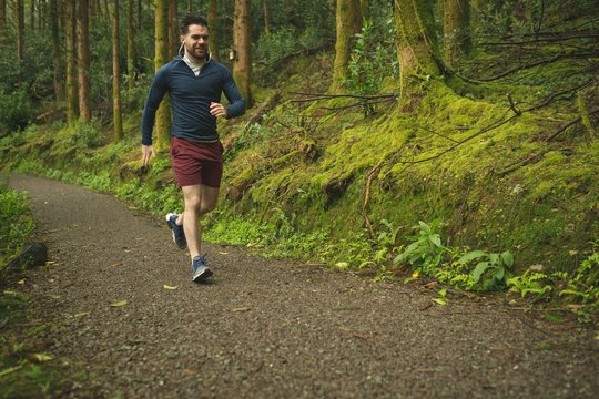 Man jogging in lush forest