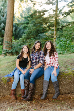 Mother and Daughters Sitting on Log for Portrait