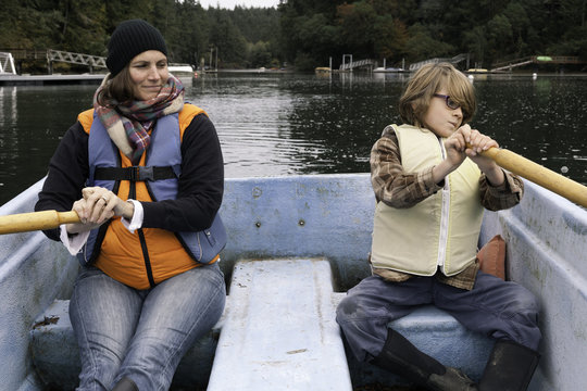 Mom and eight year old son row a boat in Fletcher Bay on a crisp autumn day