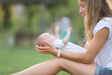 Sister cuddling her newborn baby brother