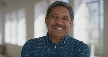 portrait of middle aged hispanic man smiling confident looking at camera cheerful retired mature male enjoying lifestyle wearing blue shirt - Powered by Adobe