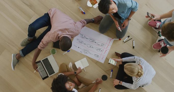 young diverse marketing team brainstorming business strategy sharing ideas drawing creative solution together on paper teamwork collaboration 