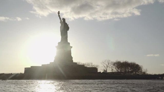 Medium shot of Statue of Liberty filmed in the sunset from the river in New York, United States of America