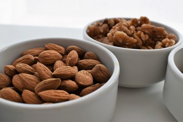 Almonds and walnuts on white pottery  containers