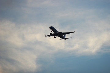 Fototapeta na wymiar Avión en vuelo con cielo parcialmente nublado