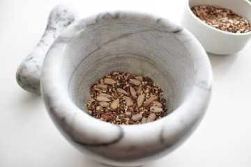 Mixture of sunflower, sesame and chia seeds in a marble morter