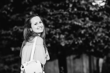 happy girl smiles and looks at the camera lens on a black and white photo
