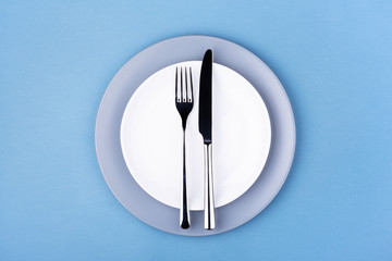 Empty plate with fork and knife. Setting table, top view.