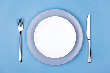 Empty plate with fork and knife. Setting table, top view.