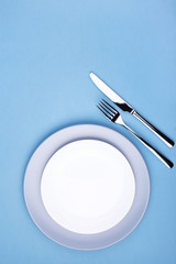 Empty plate with fork and knife. Setting table, top view, vertical