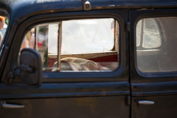 Fototapeta premium view of the steering wheel and dashboard retro car behind the driver's door