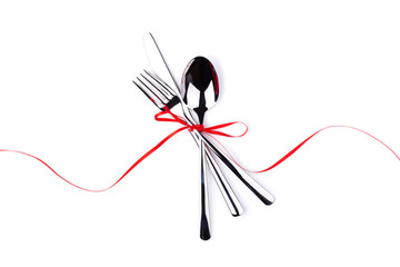 Fork, spoon and knife tied with red ribbon. Isolated on white.