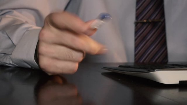 Businessman nervously turning a pen in his hand 4K