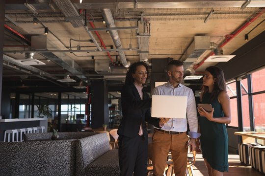 Business executives discussing over laptop