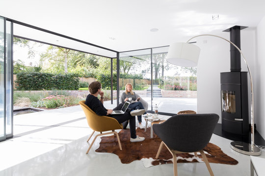 Fototapeta Couple relaxing in the spacious garden room of their modern house.