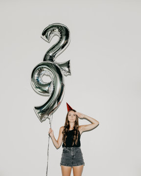 A Woman Holding 29 Number Birthday Balloons