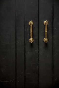 golden knob on a black wooden door