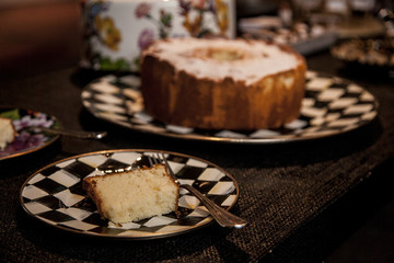 slice of cake with powder sugar on top on a dark wood background. selective focus