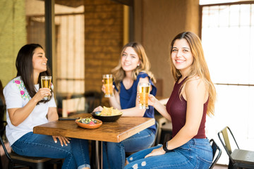 Woman with friends drinking beer at restaurant