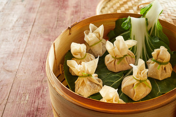 Dim sum dumplings with cabbage in bamboo basket