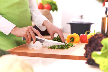 Close Up of human hands cooking vegetable salad in kitchen on the glass table with reflection. Healthy meal, and vegetarian food concept