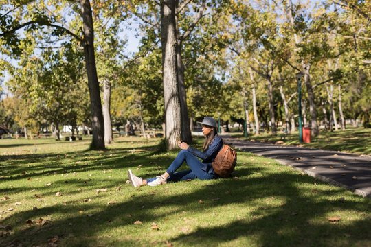 Woman sitting in the park using mobile phone