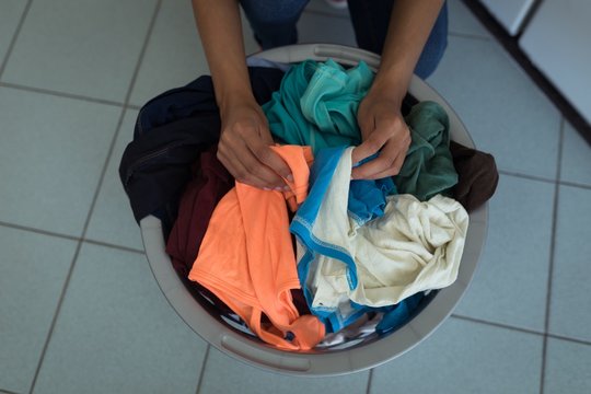 Woman sorting clothes in the laundry basket
