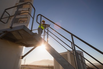 Engineer using a laptop at entrance of a wind mill