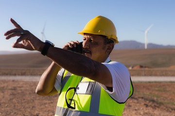 Engineer talking on mobile phone at wind farm