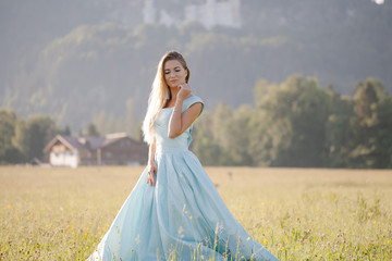 Fototapeta na wymiar blond girl in blue dress infront of the castle