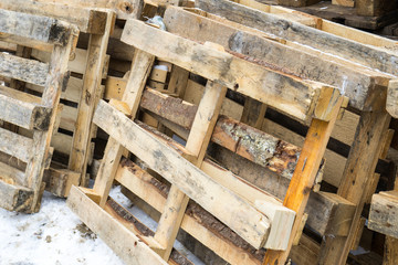 Wooden pallets are piled on a heap.