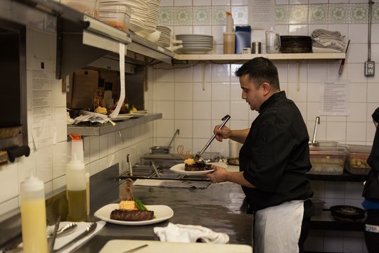Male chef serving food in a plate