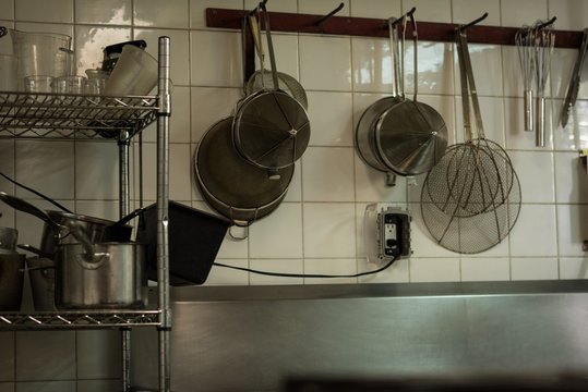 Steel stainer hanging on hook in kitchen