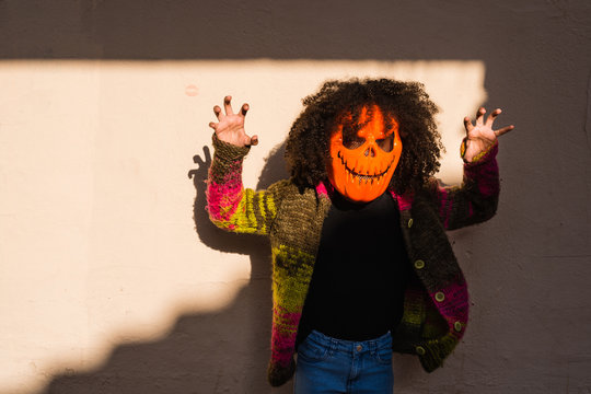 Scary halloween pumpkin over sunlit wall.