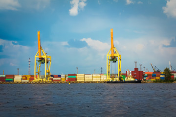 ship loading cranes in the container terminal in Riga, Latvia in the summer cloudy day